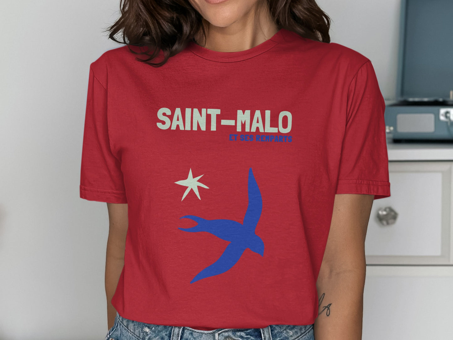 Red t-shirt with Saint-Malo text, a star, and a blue bird graphic.