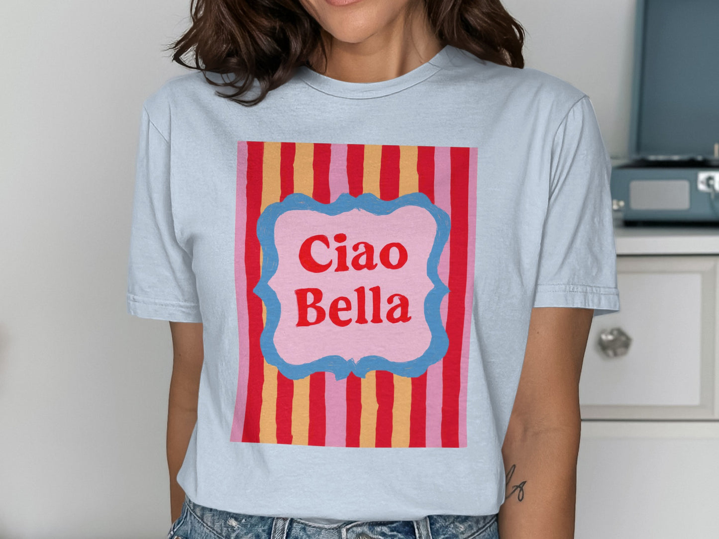 Light blue t-shirt with "Ciao Bella" text in a pink framed box.