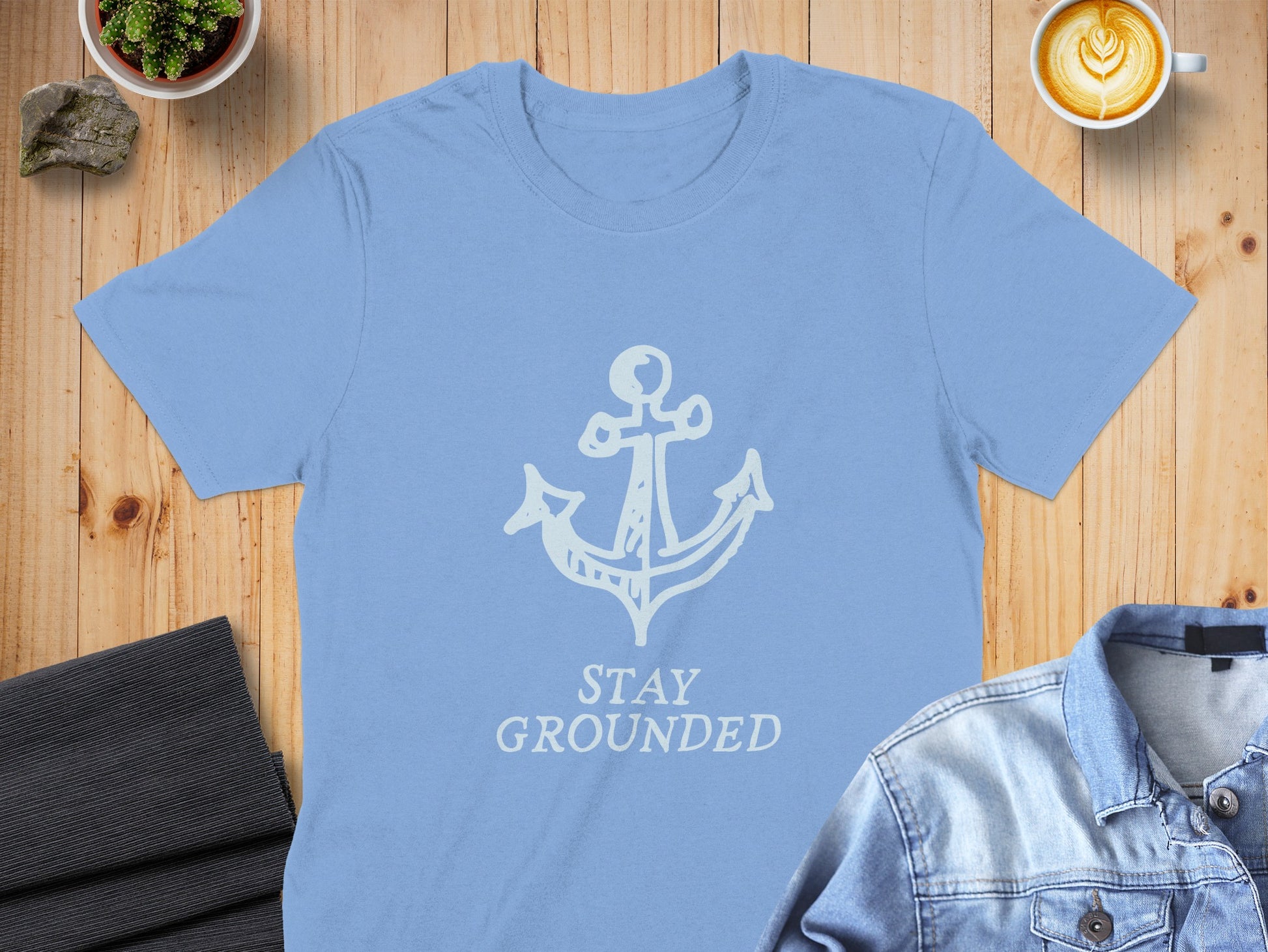 Light blue t-shirt with white anchor and "STAY GROUNDED" text.