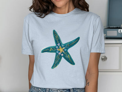 Light blue t-shirt with a turquoise starfish design featuring floral accents.