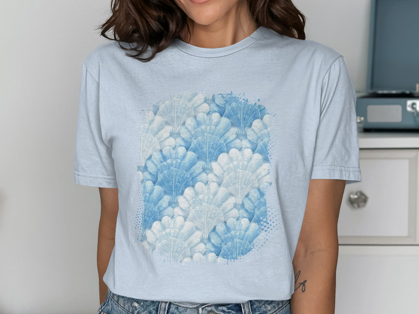 Light blue t-shirt with a white and blue seashell pattern.