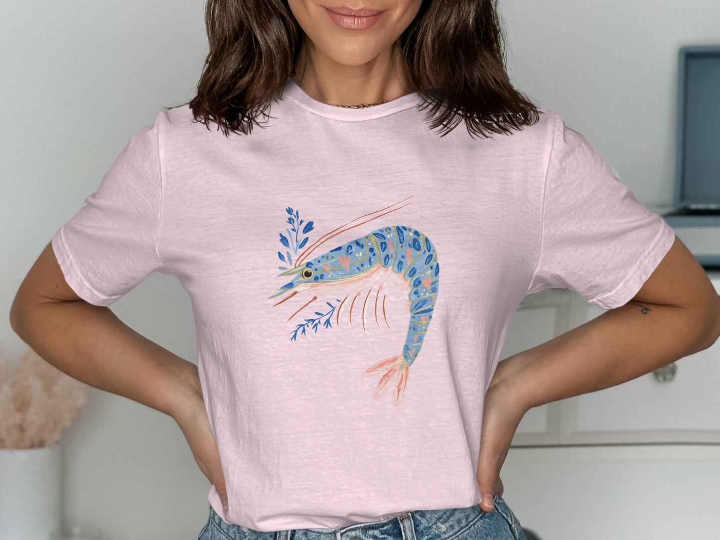 Pink t-shirt with a blue and orange shrimp and blue floral design.