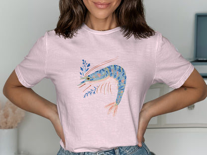 Pink t-shirt with a blue and orange shrimp and blue floral design.