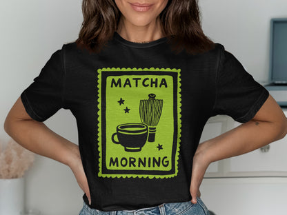 Black t-shirt with green stamp design featuring matcha cup, whisk, and text.