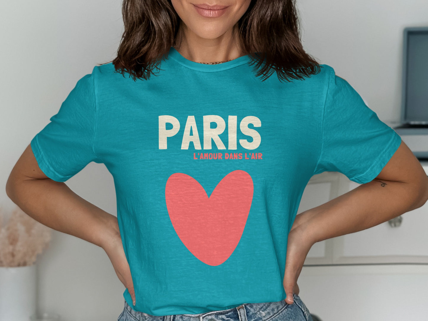 Teal t-shirt with "PARIS L'AMOUR DANS L'AIR" and a pink heart.