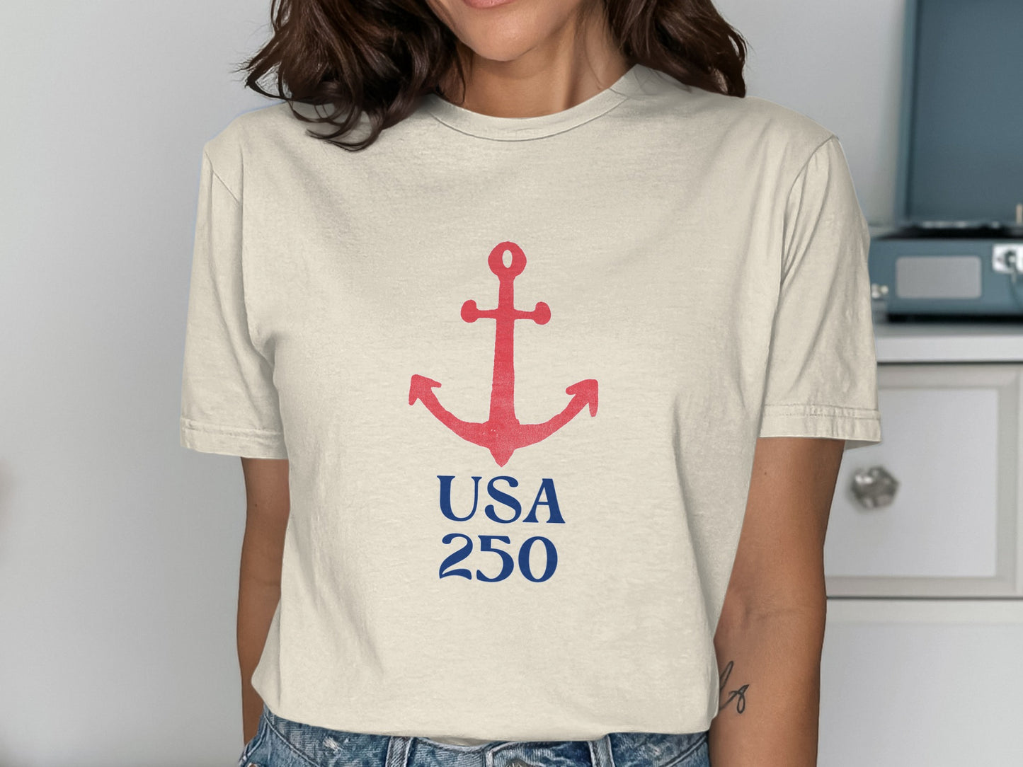 Cream t-shirt with red anchor and blue "USA 250" text.