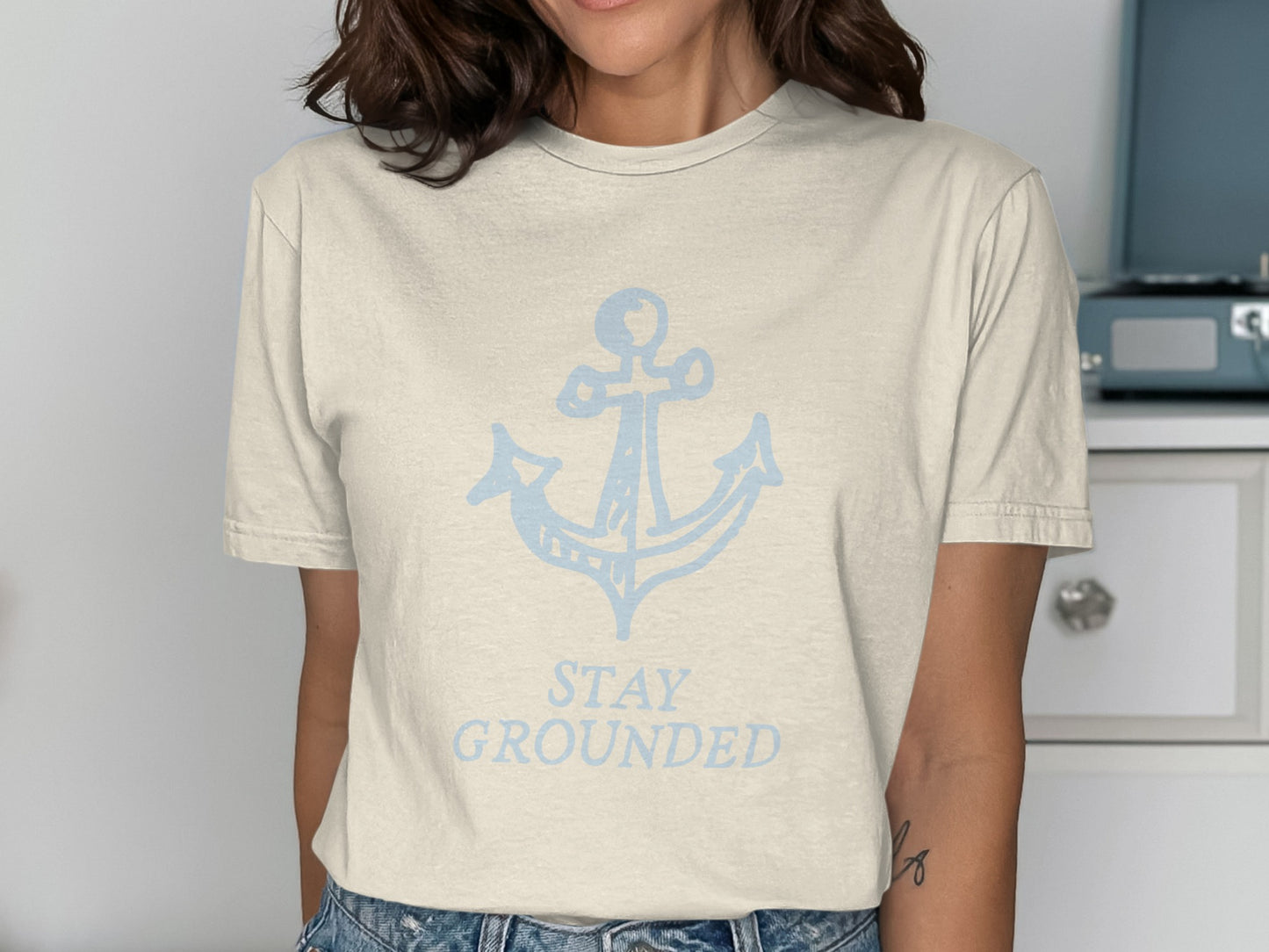 Cream t-shirt with light blue anchor graphic and "STAY GROUNDED" text.