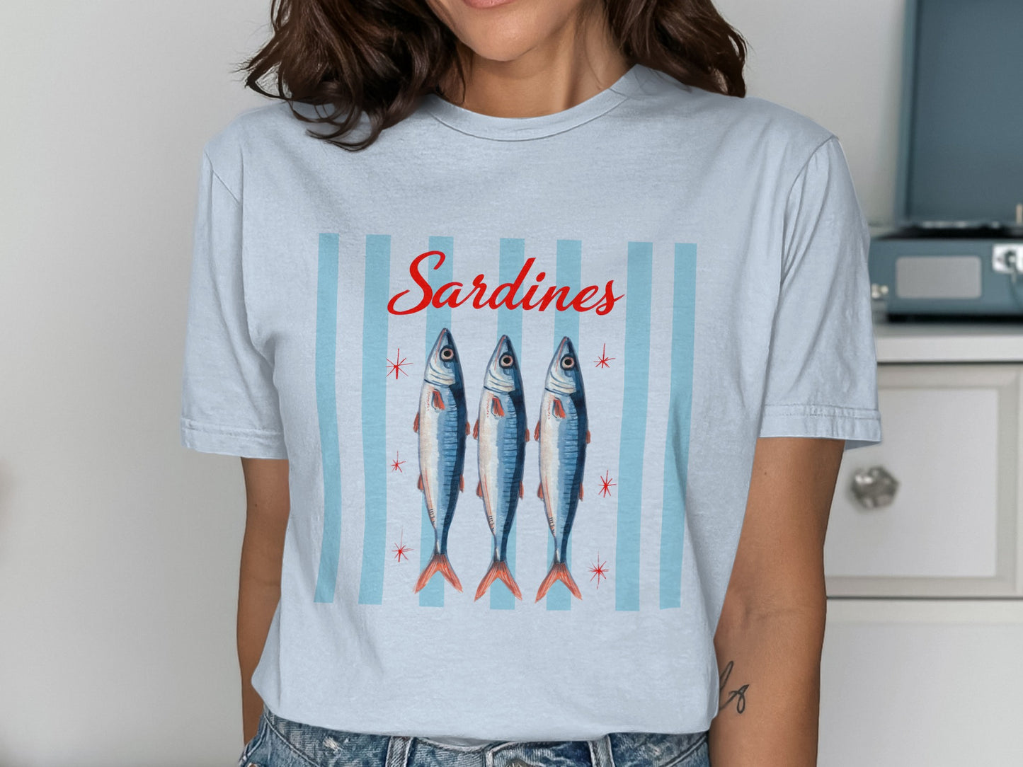 T-shirt with watercolor sardines and vertical blue stripes.