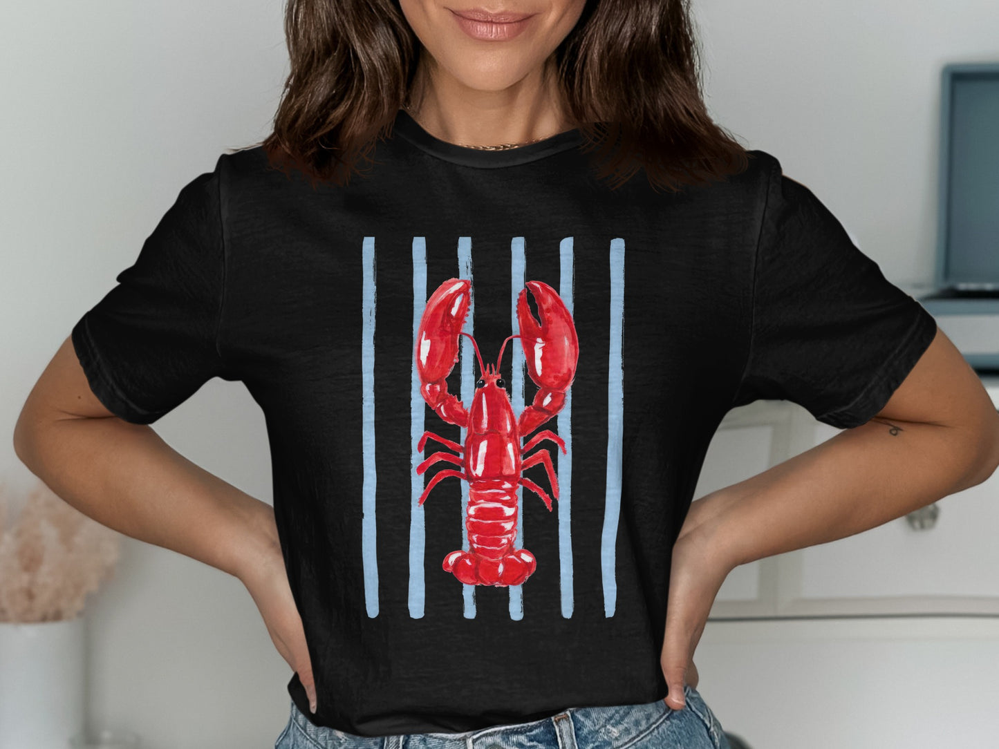 Black t-shirt with a red lobster on blue vertical stripes.