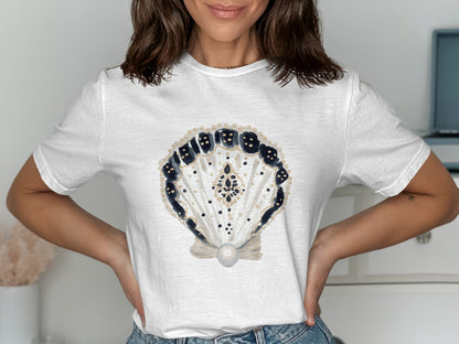 White t-shirt with a detailed seashell graphic featuring blue, gold, and black accents.