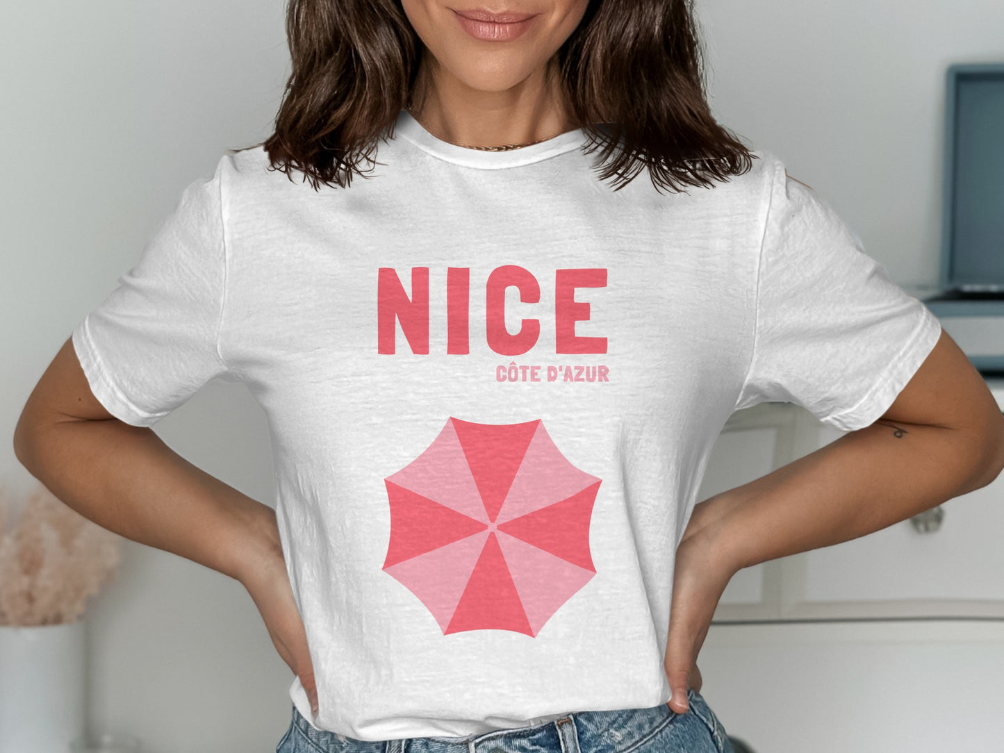 White t-shirt with "NICE CÔTE D'AZUR" and a pink umbrella graphic.
