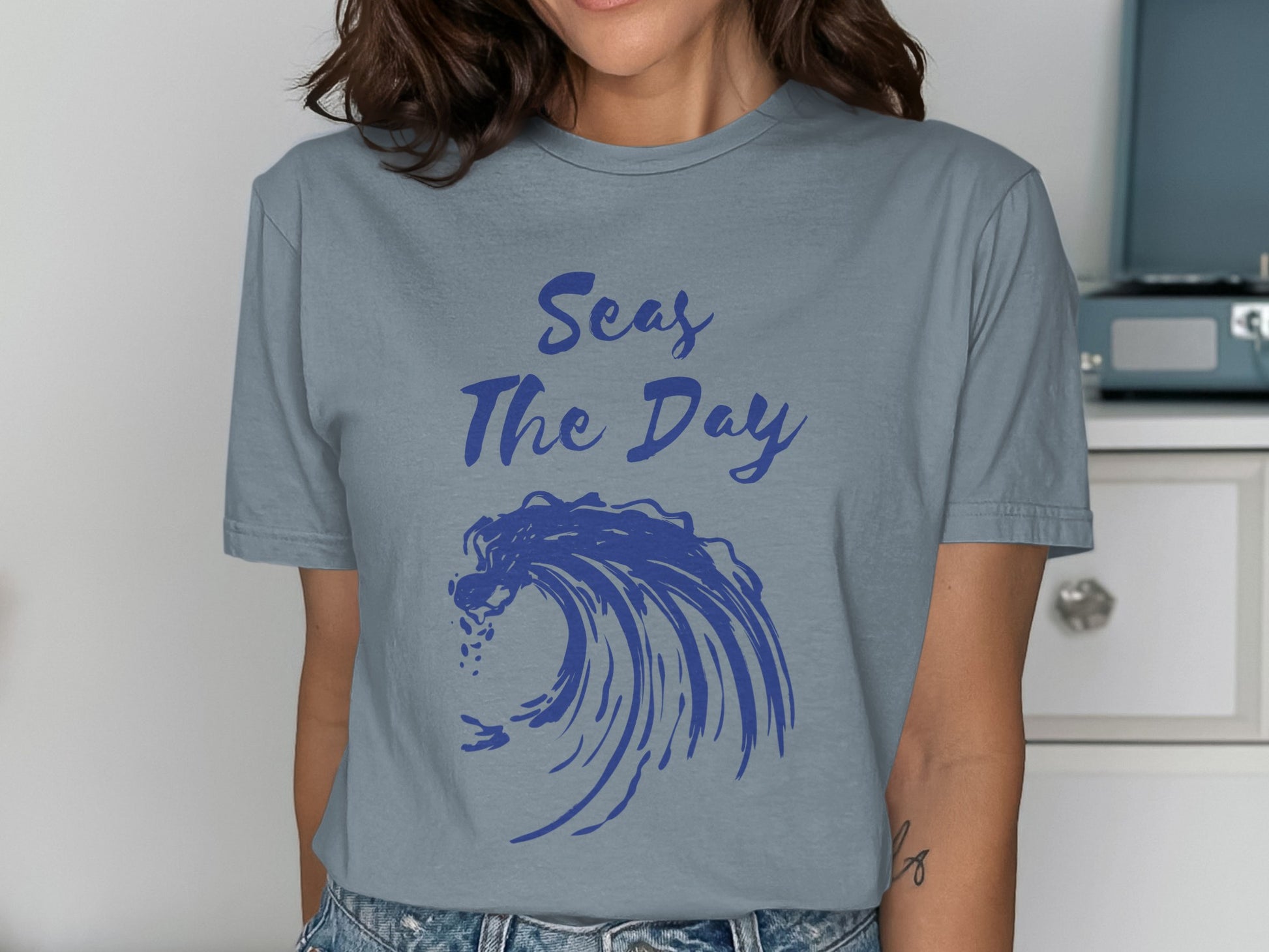 Gray t-shirt with blue text "Seas The Day" and a large blue wave.