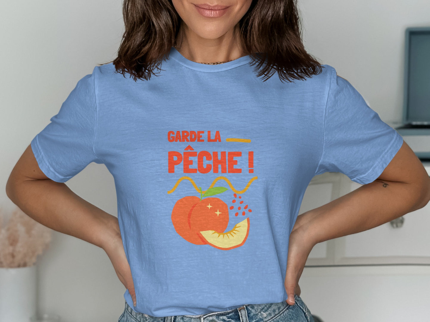 Blue t-shirt with "Garde la pêche!" text and peach graphic.