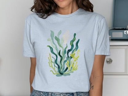 Light blue t-shirt with a green and yellow watercolor seaweed design.