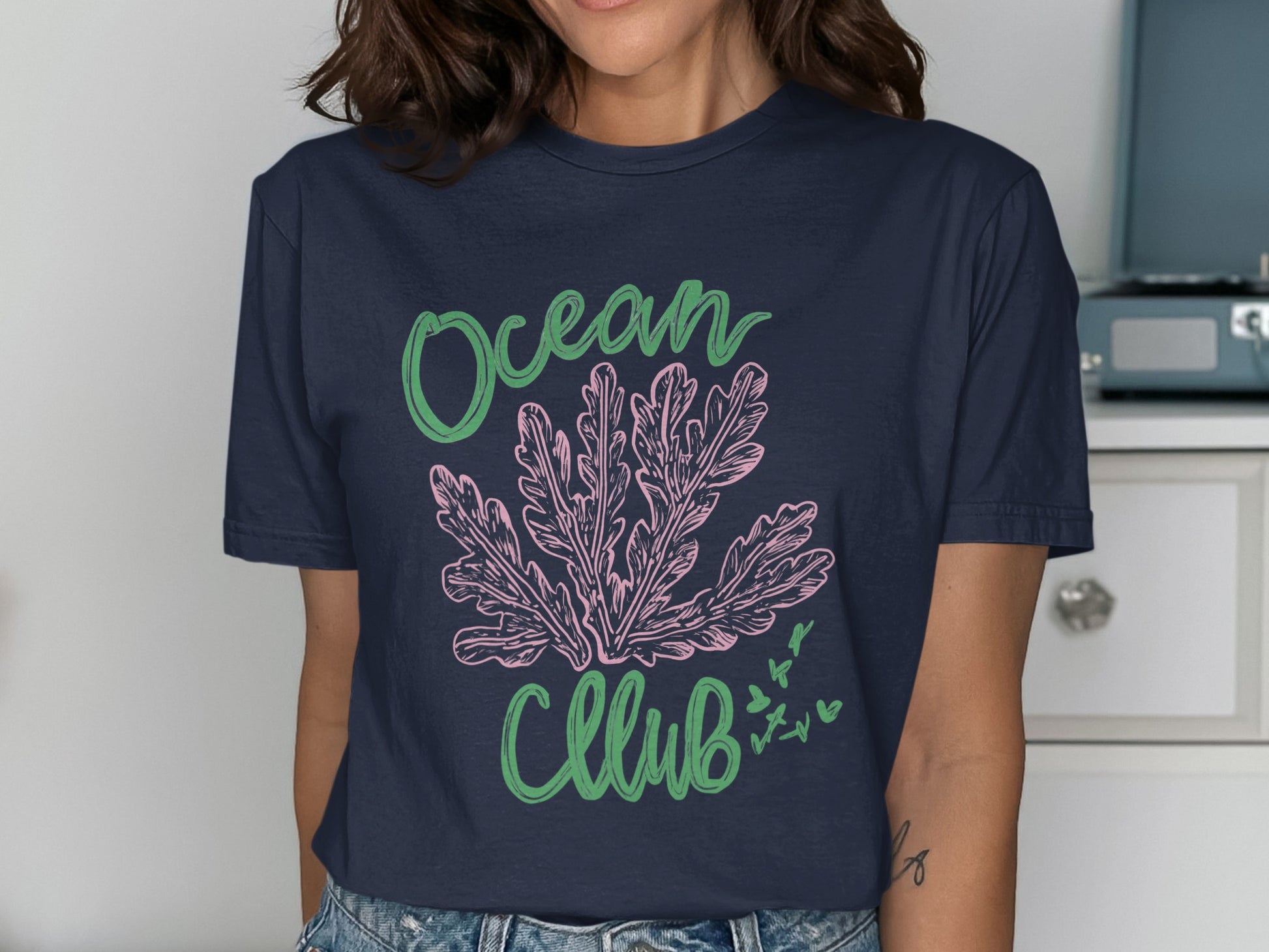 Navy t-shirt with pink coral and green "Ocean Club" text.