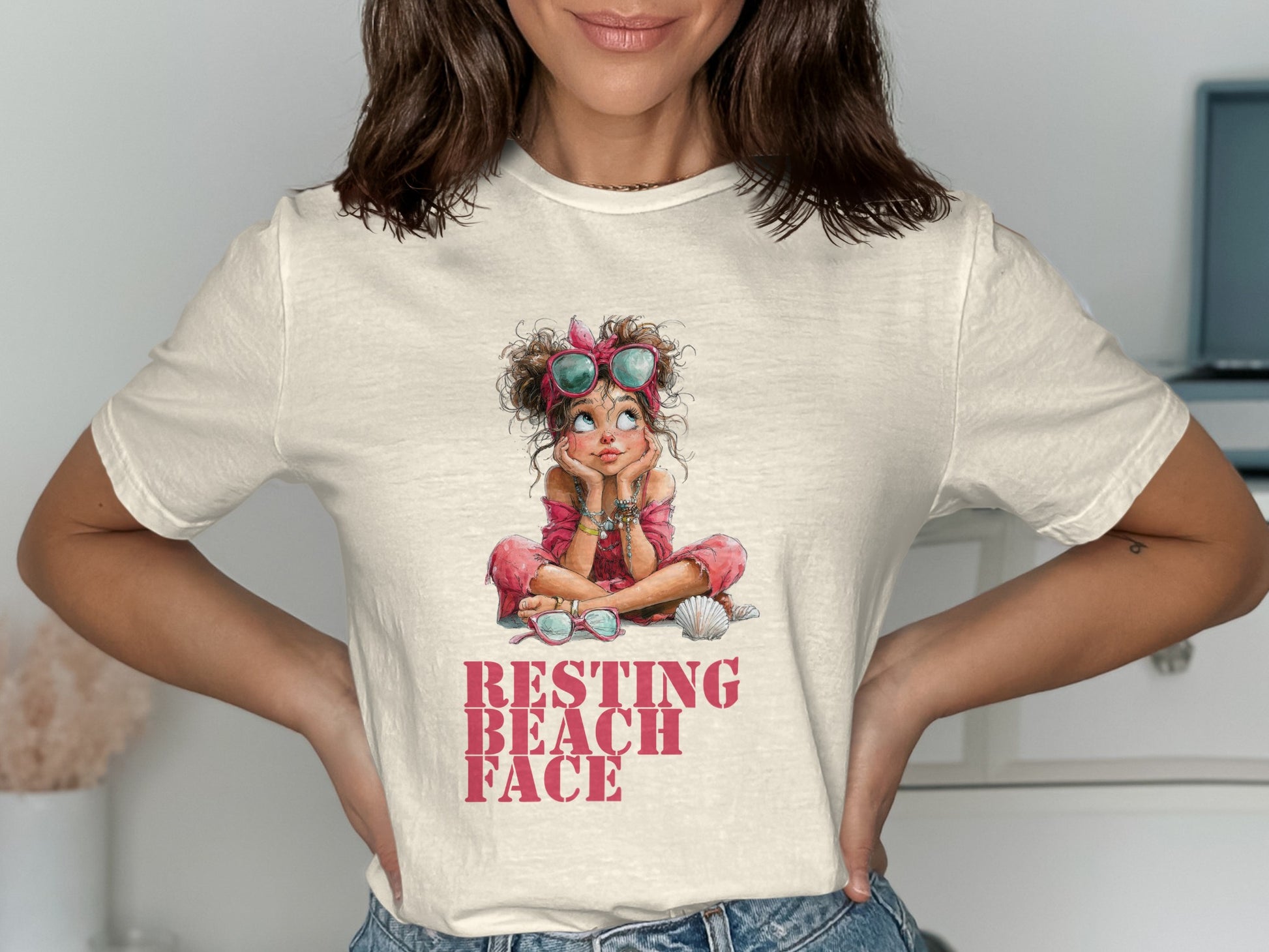 Woman wearing a cream t-shirt with a "Resting Beach Face" graphic.