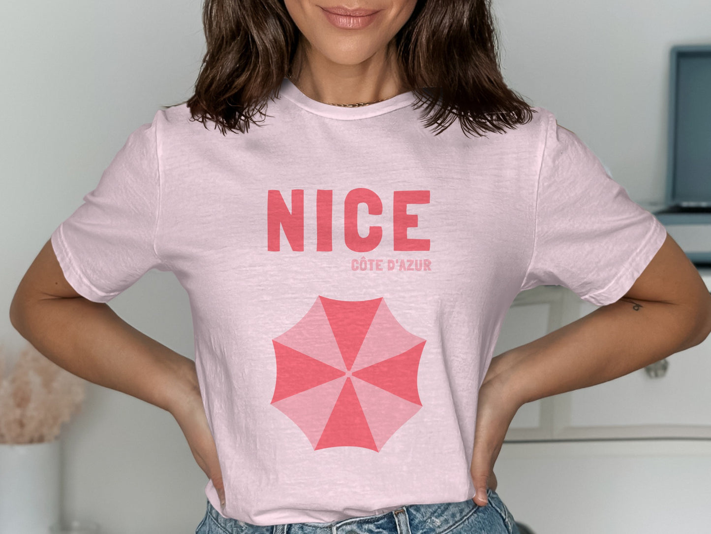 Pink t-shirt with "NICE CÔTE D'AZUR" and an open umbrella graphic.
