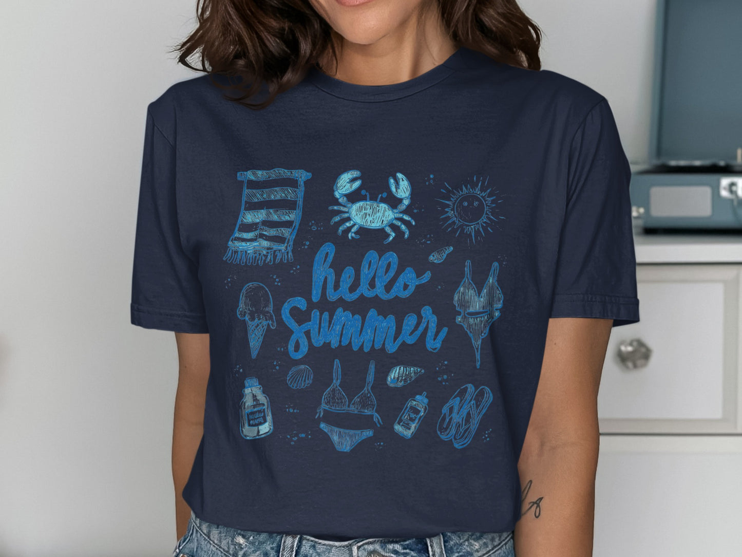 Blue t-shirt with hand-drawn summer beach icons and "Hello Summer" text.