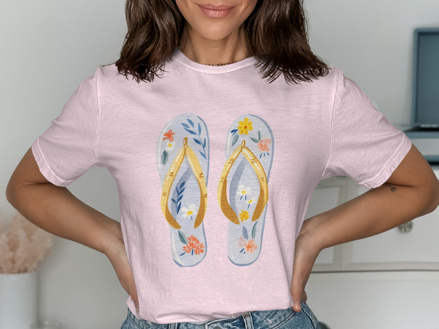 Light pink t-shirt with a graphic of two floral flip-flops.