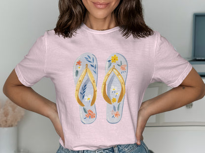 Light pink t-shirt with a graphic of two floral flip-flops.