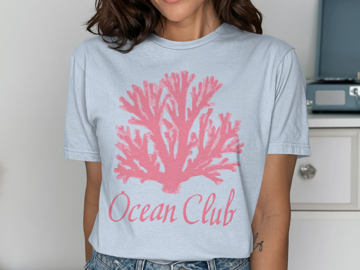 Light blue t-shirt with pink coral graphic and "Ocean Club" text.