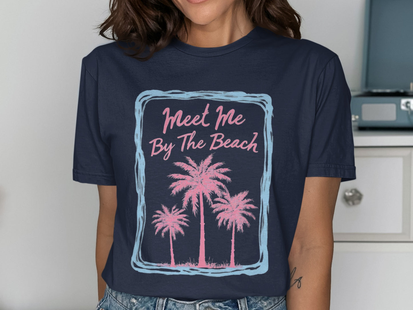 Navy t-shirt with "Meet Me By The Beach" and pink palm trees.