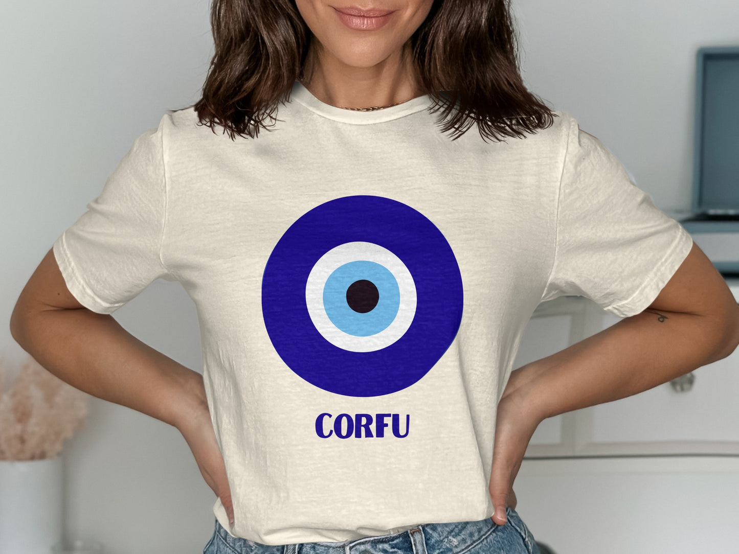 Cream t-shirt with blue and white evil eye graphic and "CORFU" text.