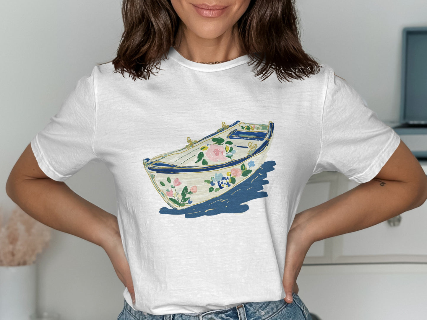 White t-shirt with a watercolor illustration of a floral rowboat.