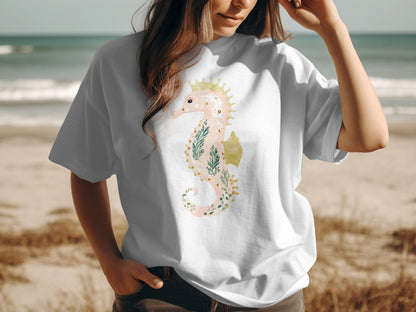 White t-shirt featuring a light pink seahorse with green foliage design.