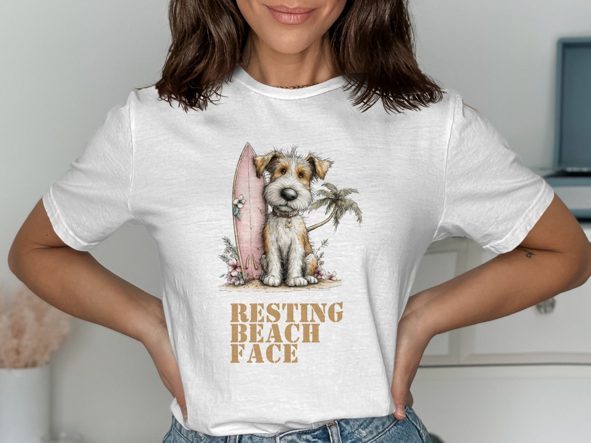 Dog with surfboard and palm tree on t-shirt reading "RESTING BEACH FACE."