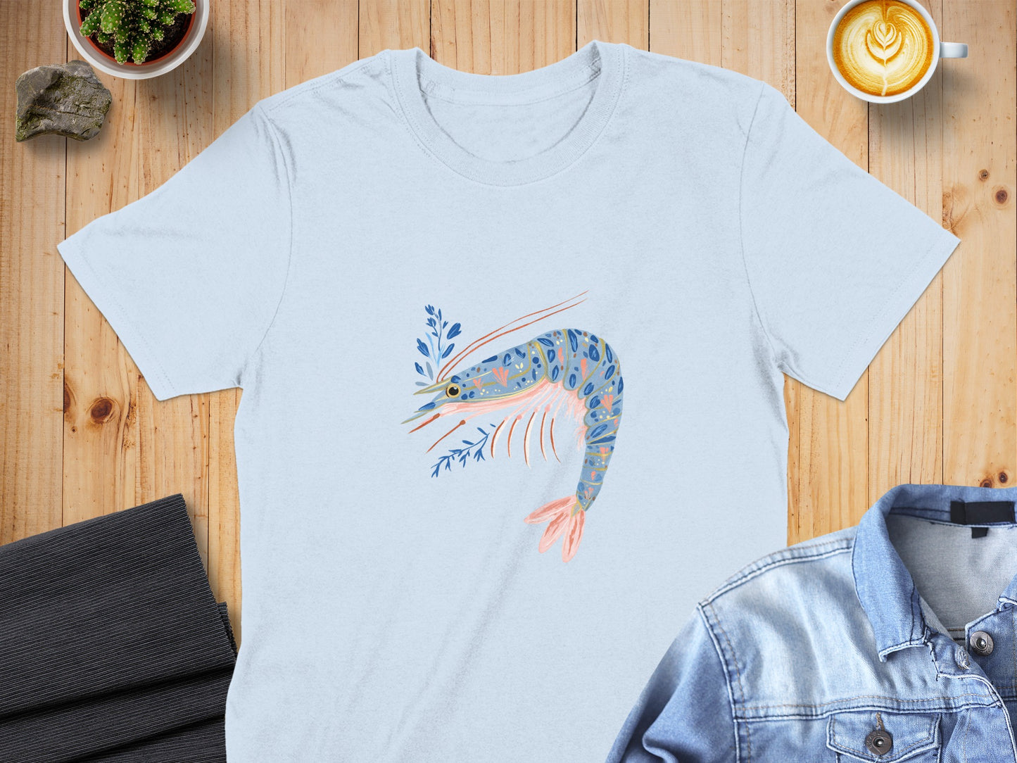 Light blue t-shirt with a stylized pink and blue shrimp graphic.