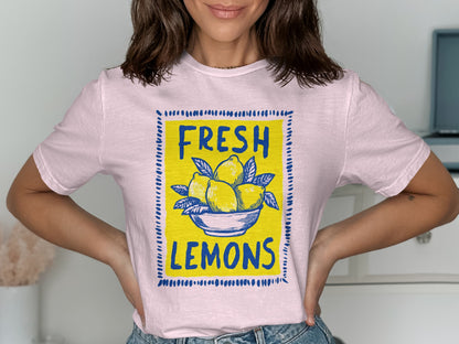 Pink t-shirt with blue square frame featuring "FRESH LEMONS" and a bowl of lemons.