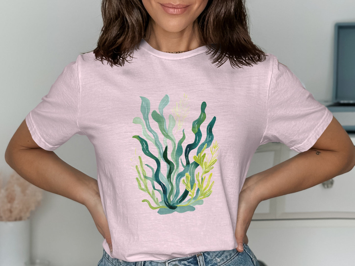 Pink t-shirt with a colorful illustration of seaweed and kelp.