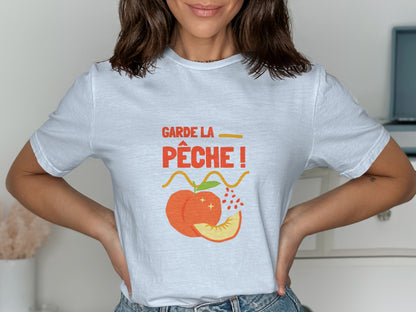 White t-shirt with "Garde la pêche!" text and peach illustration.