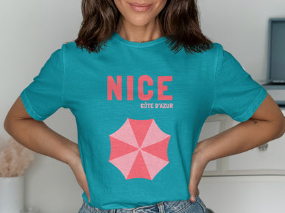 Teal t-shirt with "NICE CÔTE D'AZUR" and a pink umbrella graphic.