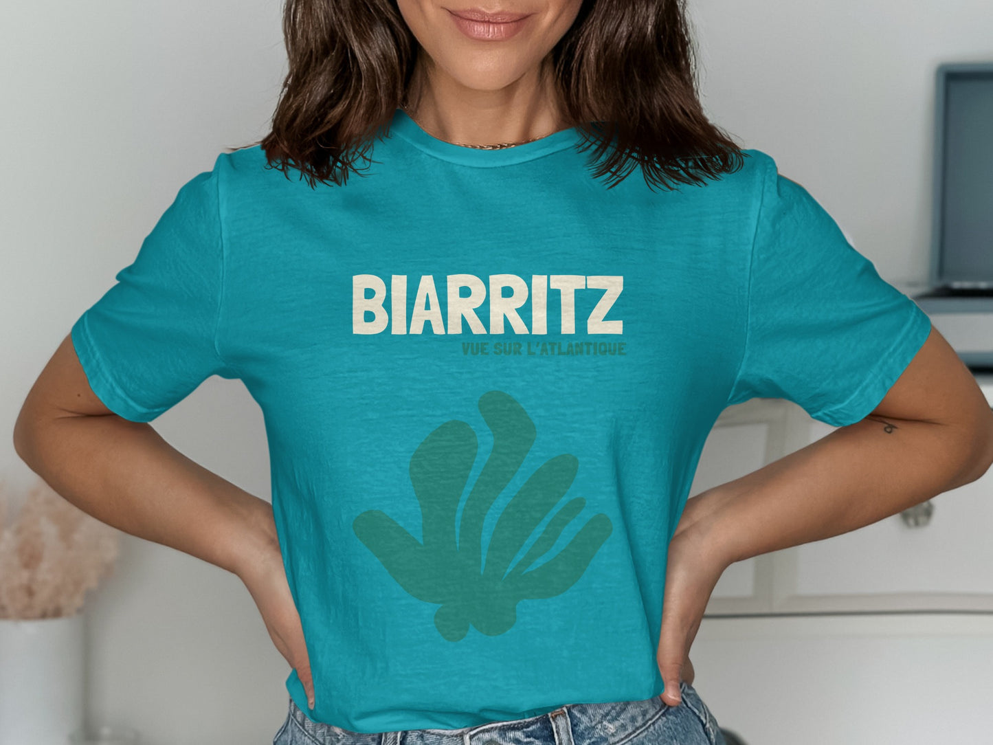Teal t-shirt with BIARRITZ and VUE L'ATLANTIQUE text, and abstract green shape.