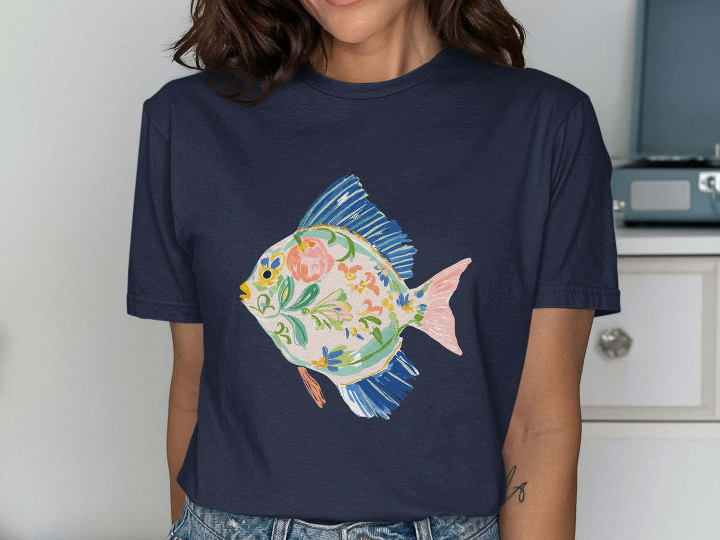 Navy t-shirt with a colorful floral fish illustration.