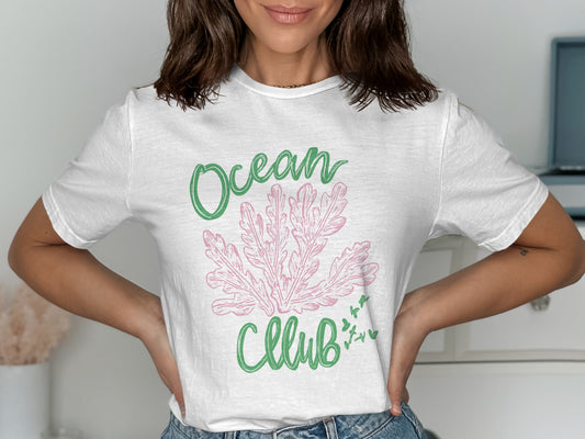 White t-shirt with green "Ocean" and pink "Club" text and coral illustration.