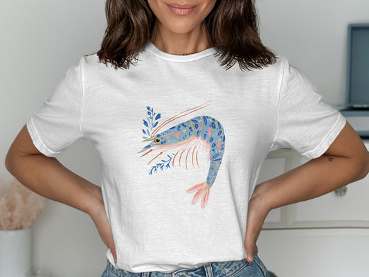 White t-shirt featuring a blue and pink shrimp illustration with blue foliage.