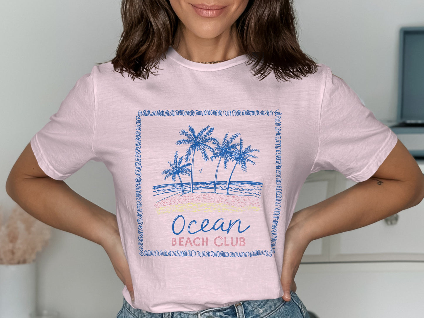 Pink t-shirt with "Ocean Beach Club" text and palm trees graphic.