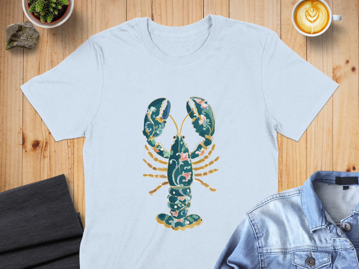 Light blue t-shirt with ornate green and pink lobster graphic.