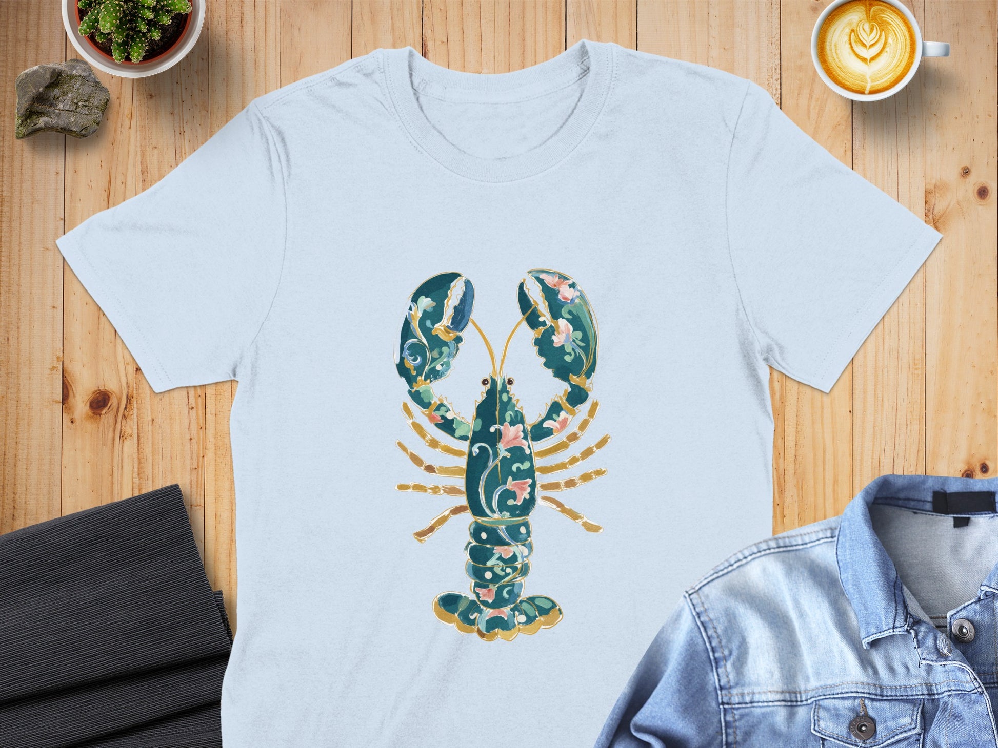 Light blue t-shirt with ornate green and pink lobster graphic.