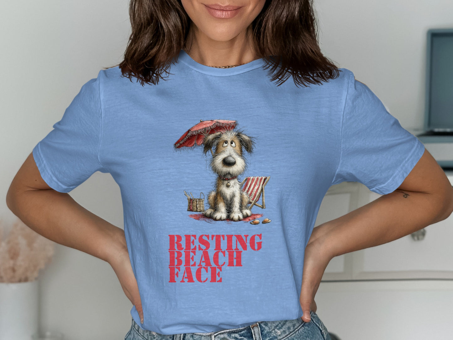 T-shirt with cartoon dog sitting under an umbrella with text "Resting Beach Face".