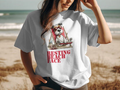 White t-shirt with graphic of a dog relaxing on a beach chair, text "RESTING BEACH FACE".