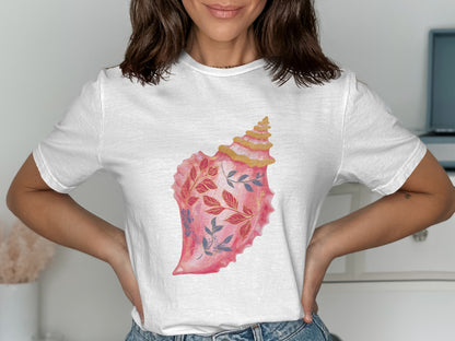 White t-shirt with a pink seashell design featuring blue floral accents.