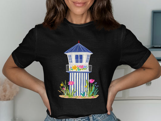 Black t-shirt featuring a watercolor illustration of a blue and white lifeguard tower with flowers.