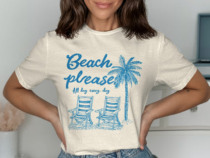 Cream t-shirt with "Beach please. All day every day" and palm tree and chairs.