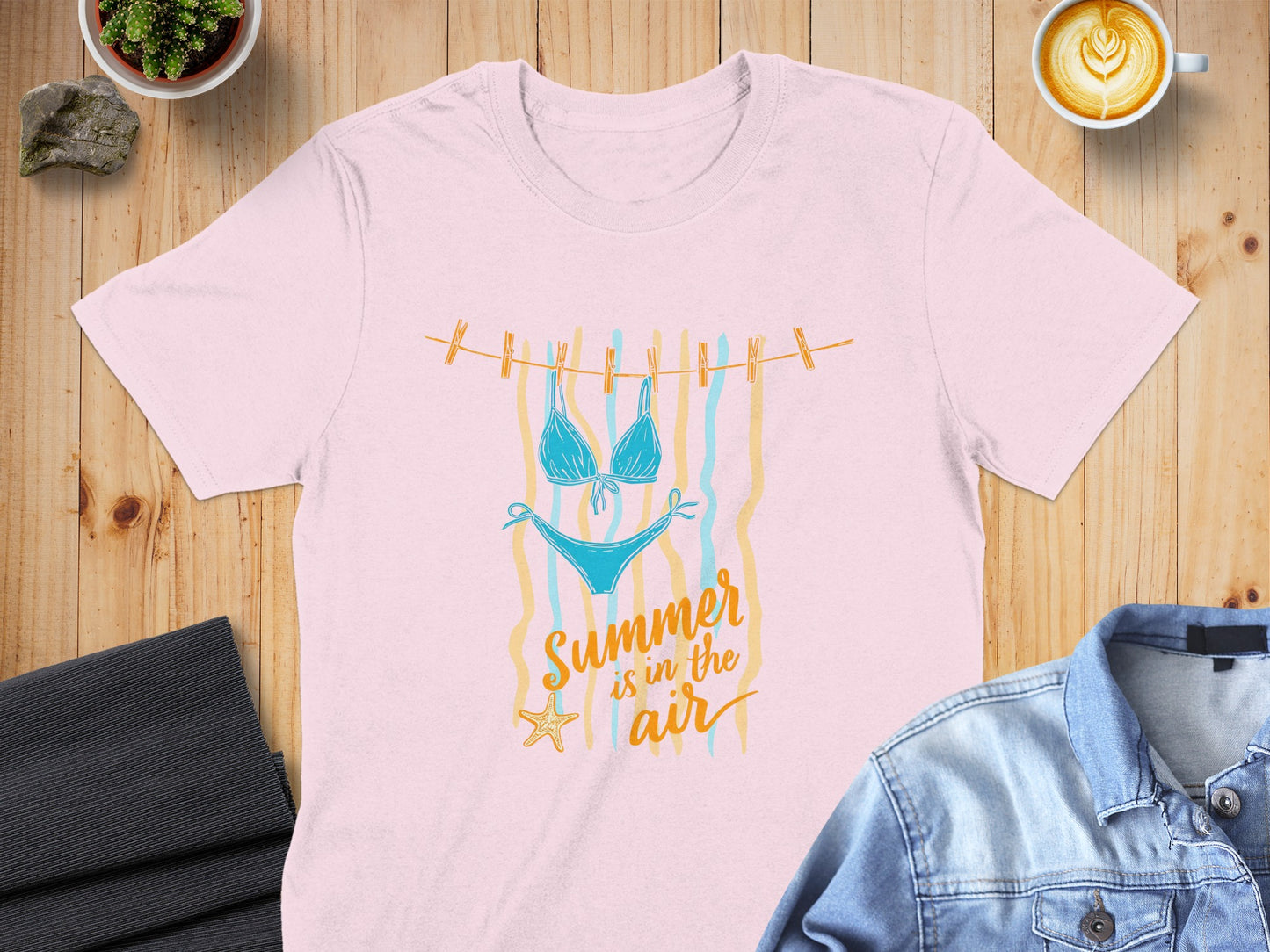 Pink t-shirt with a graphic of a bikini and text "Summer is in the air."