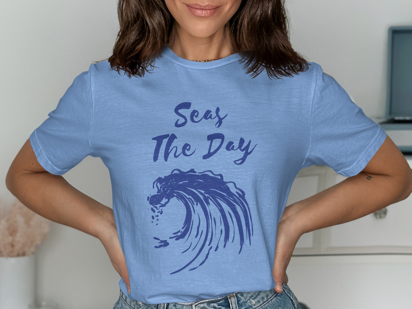 Light blue t-shirt with "Seas The Day" text and a blue wave graphic.