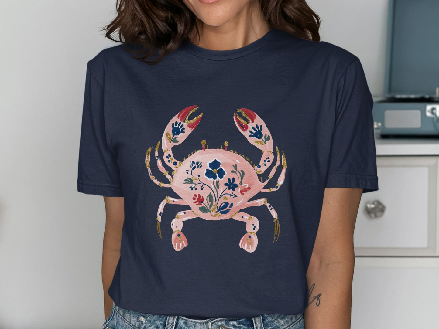 Navy t-shirt with a pink crab design featuring floral accents.